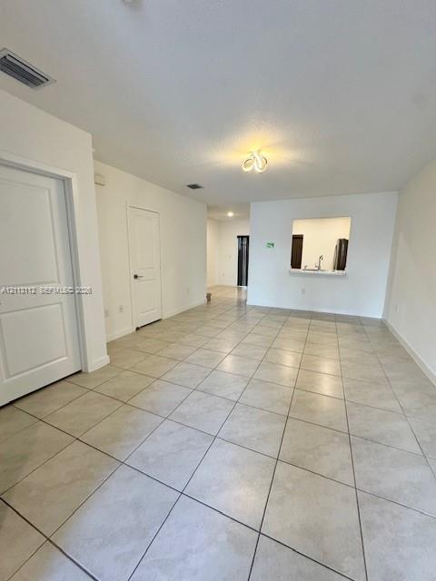Ceramic tile flooring, neutral wall finishes, multi-panel interior doors, and a kitchen pass-through opening