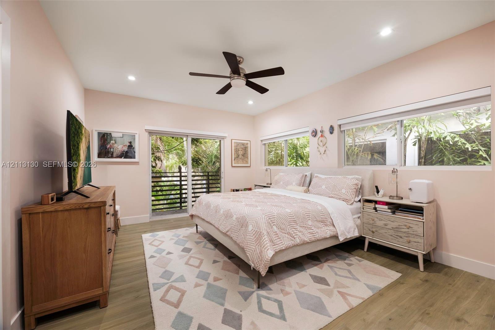 Wood-finish flooring, recessed lighting, ceiling fan, and sliding glass door with exterior balcony access
