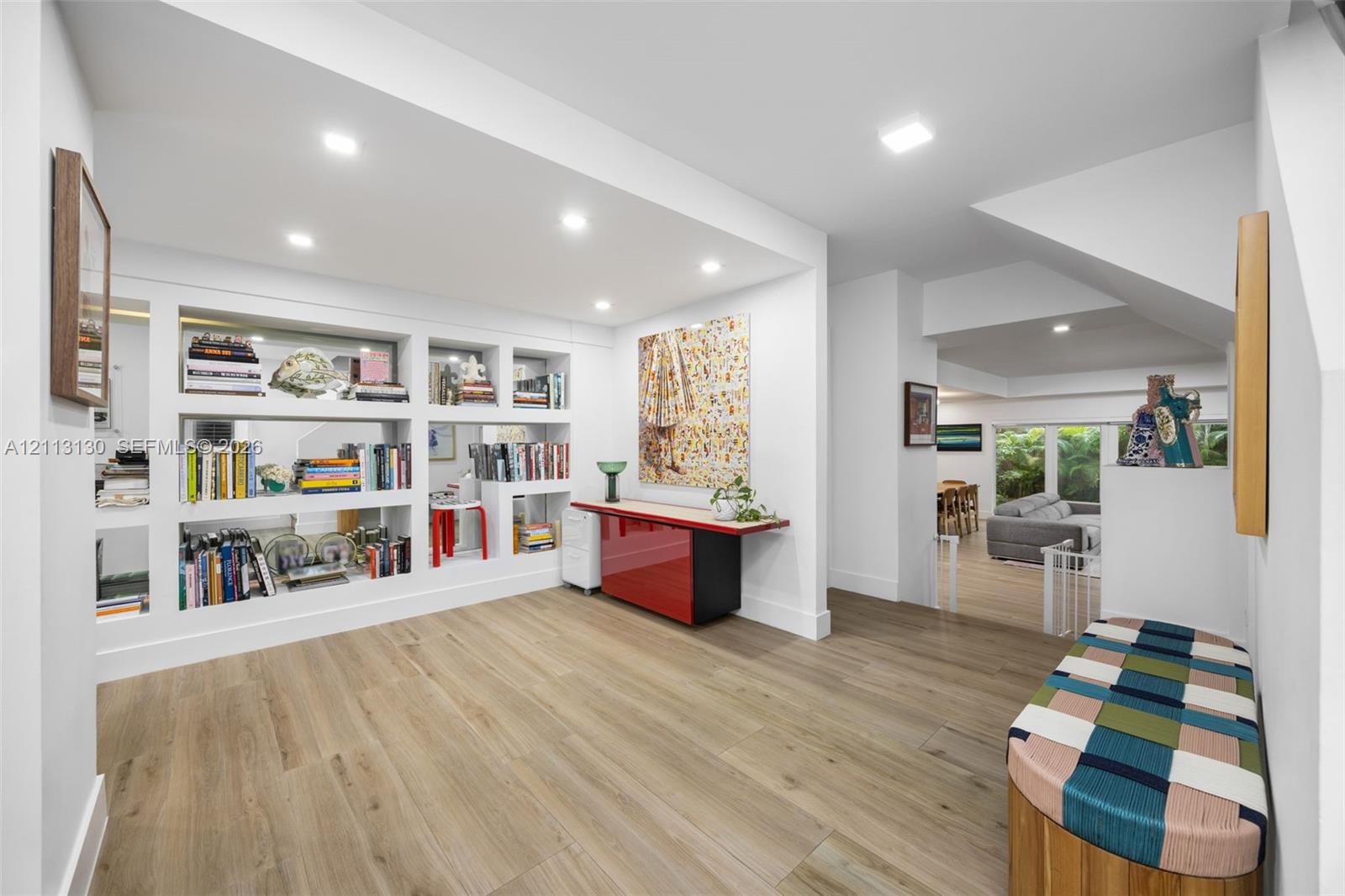 Interior space featuring wood-finish flooring, recessed lighting, and expansive built-in wall shelving with display niches