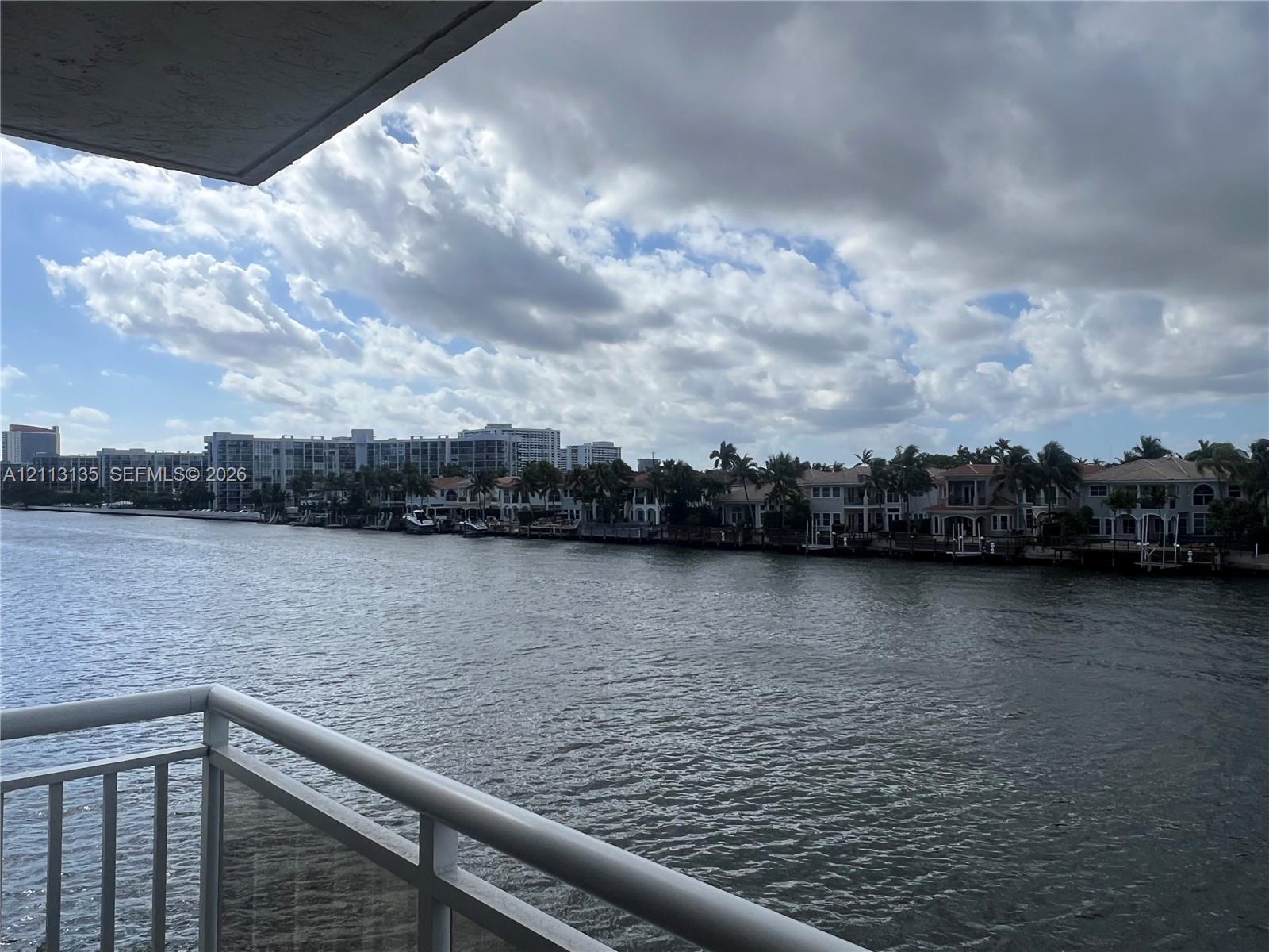 Waterfront balcony featuring a white metal railing and direct exposure to a waterway
