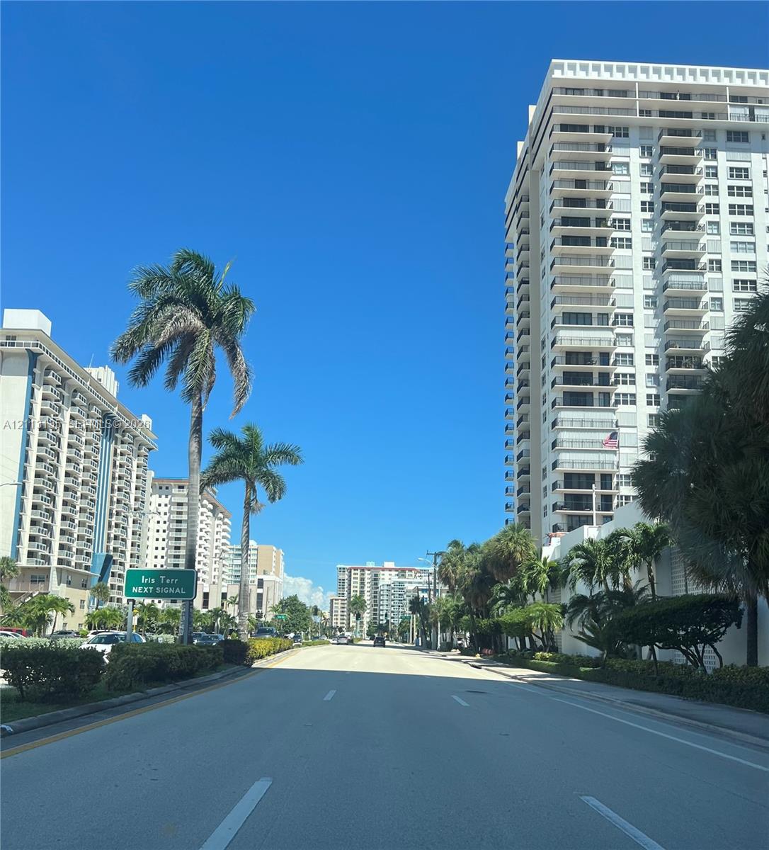 High-rise residential buildings featuring multi-level private balconies, exterior concrete structural elements, and established palm tree landscaping