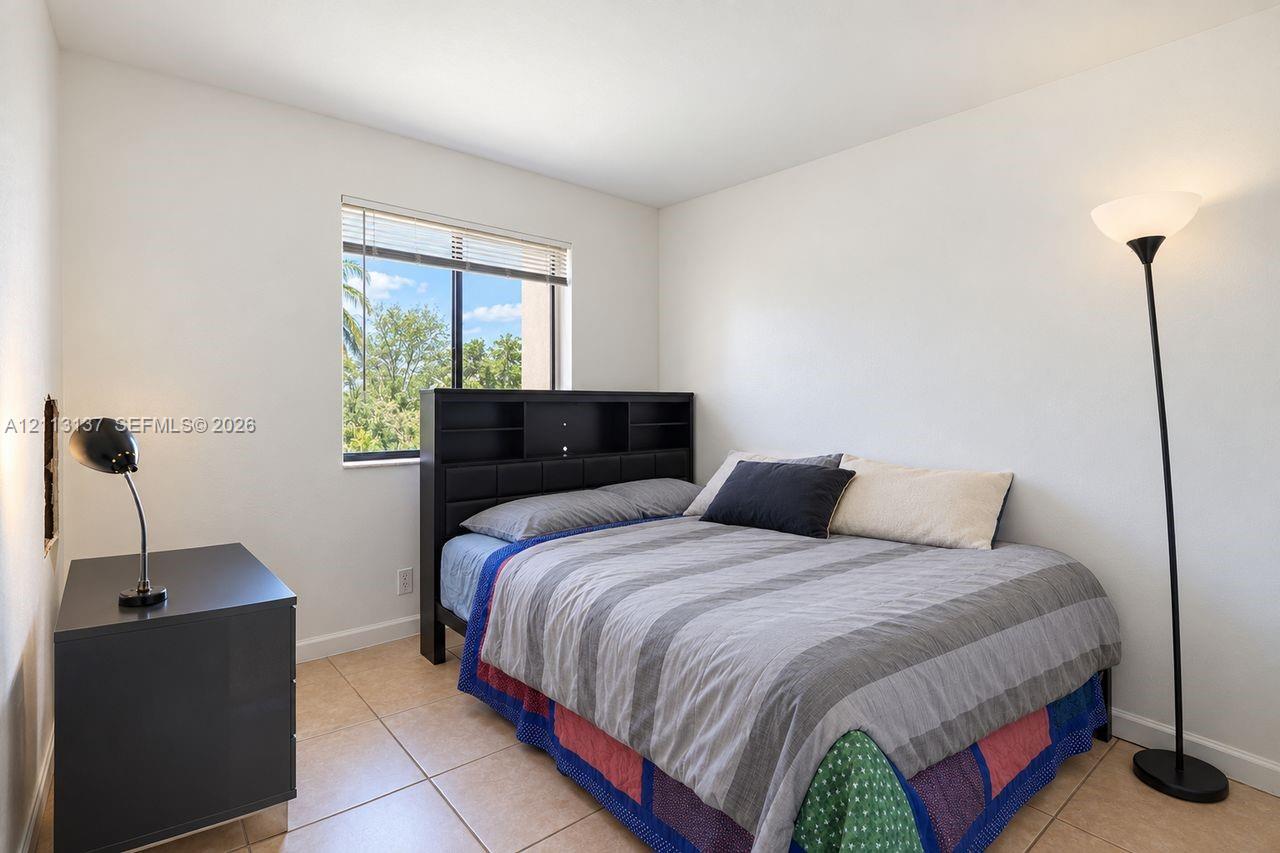 Neutral interior featuring tile flooring and a single-pane window with integrated blinds