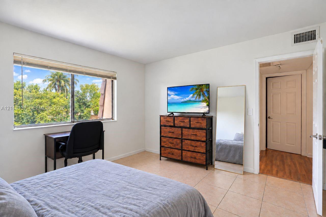 Room featuring neutral-toned tile flooring, large-format windows, and solid-core interior doors