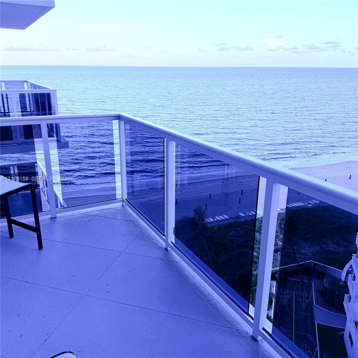 Private balcony featuring tile flooring and a glass panel railing