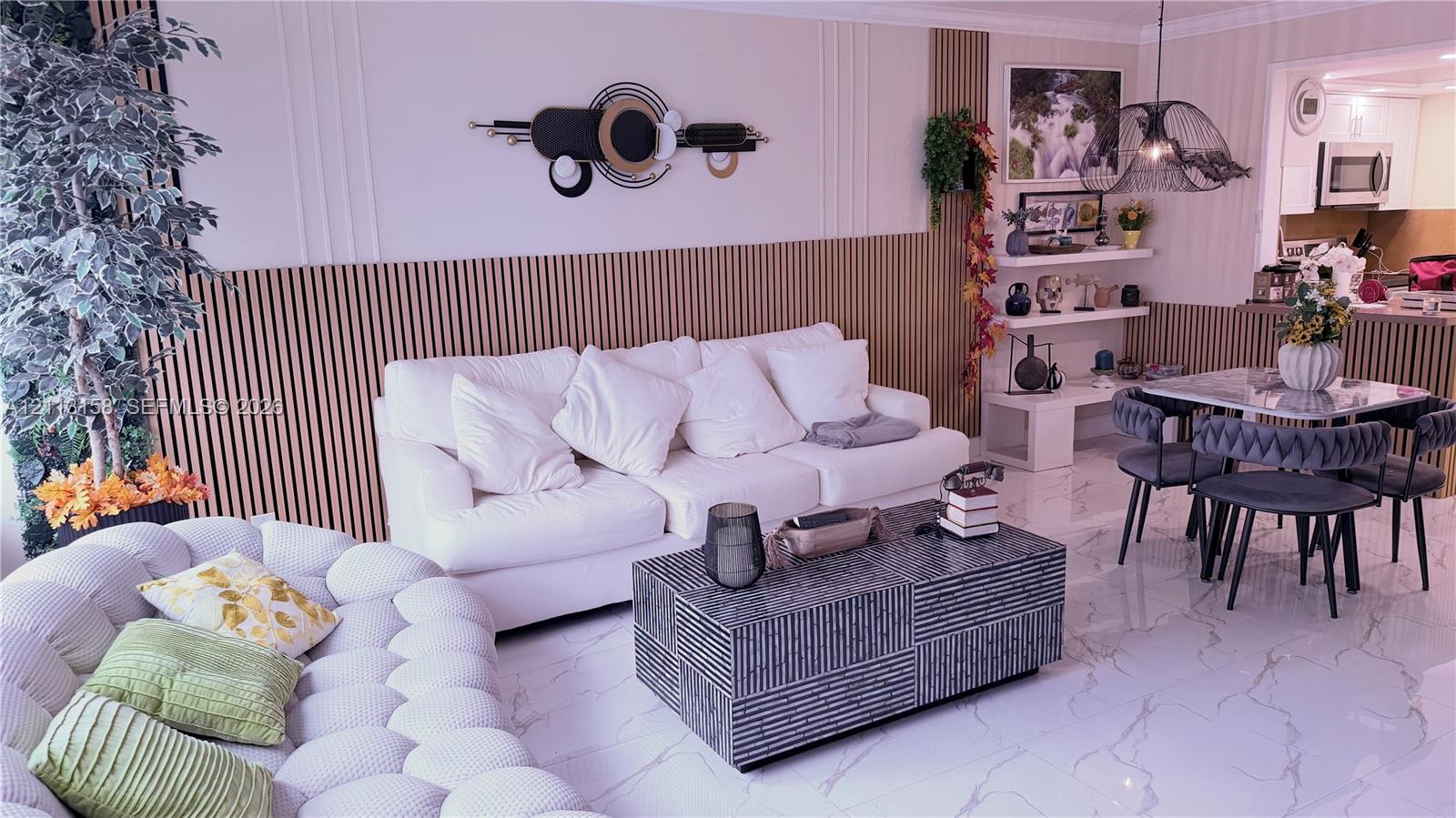 Interior space featuring vertical wood slat wall paneling, polished stone-finish flooring, built-in shelving, and a decorative pendant light fixture