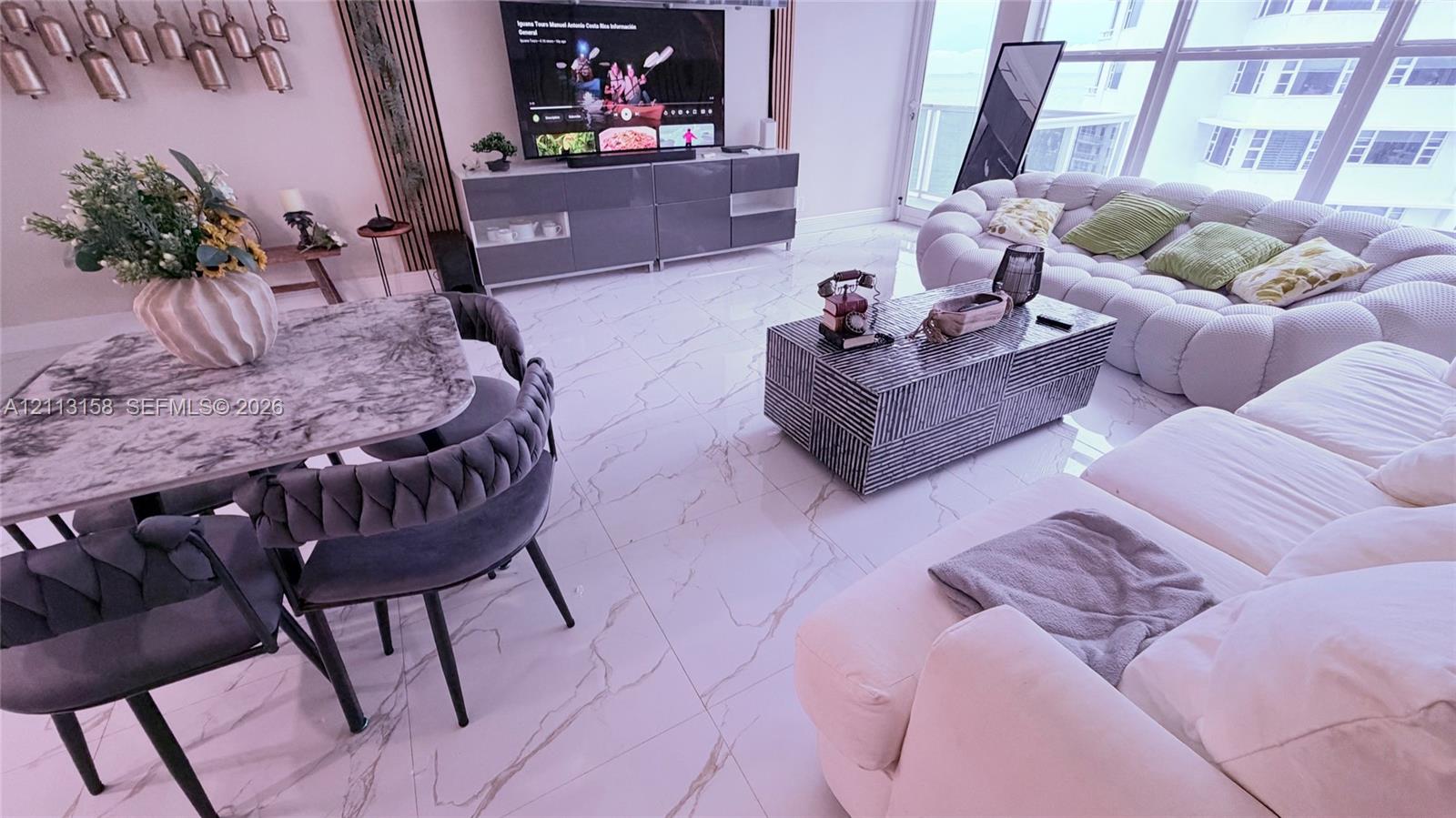 Large-format polished tile flooring, floor-to-ceiling windows, and linear wall-mounted accent paneling