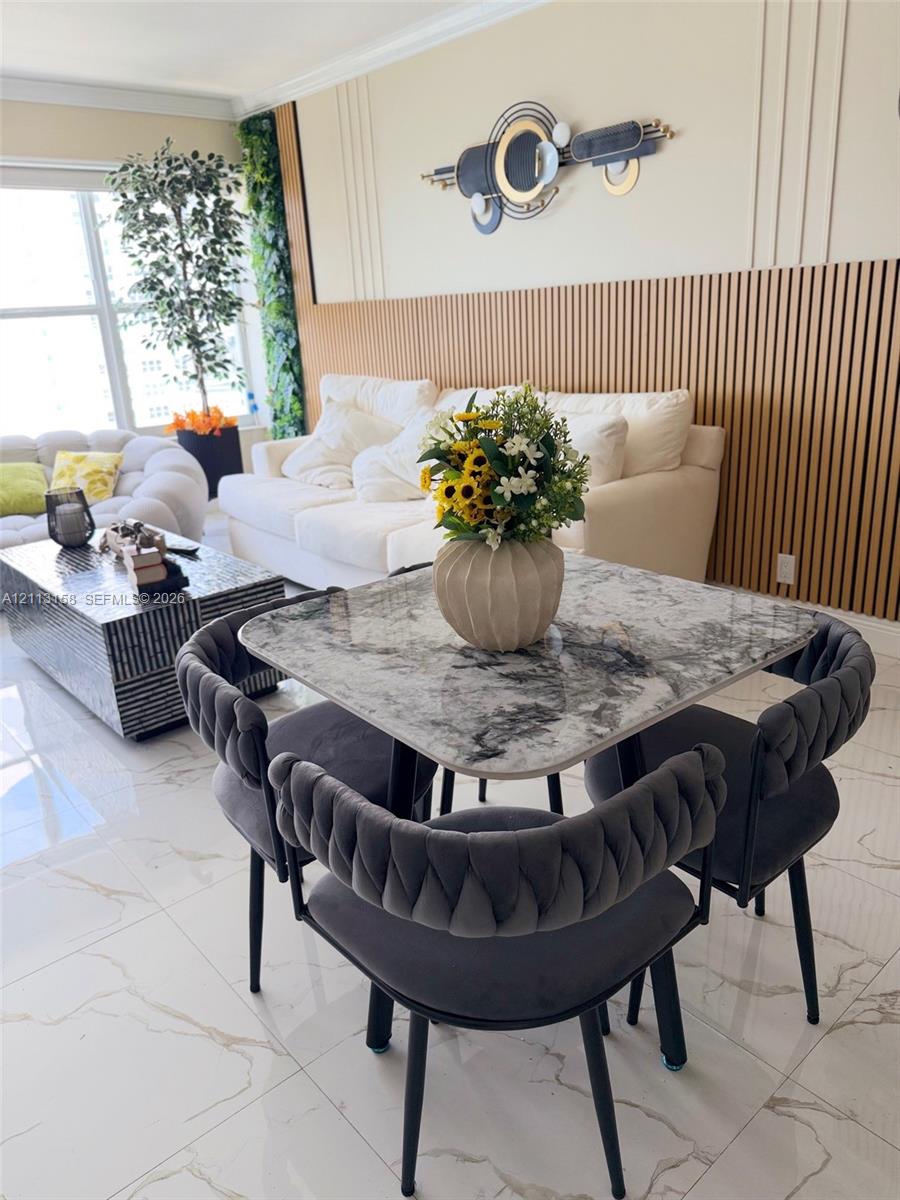 Interior space featuring large-format tile flooring, vertical wood slat wall paneling, and wall-mounted decorative trim