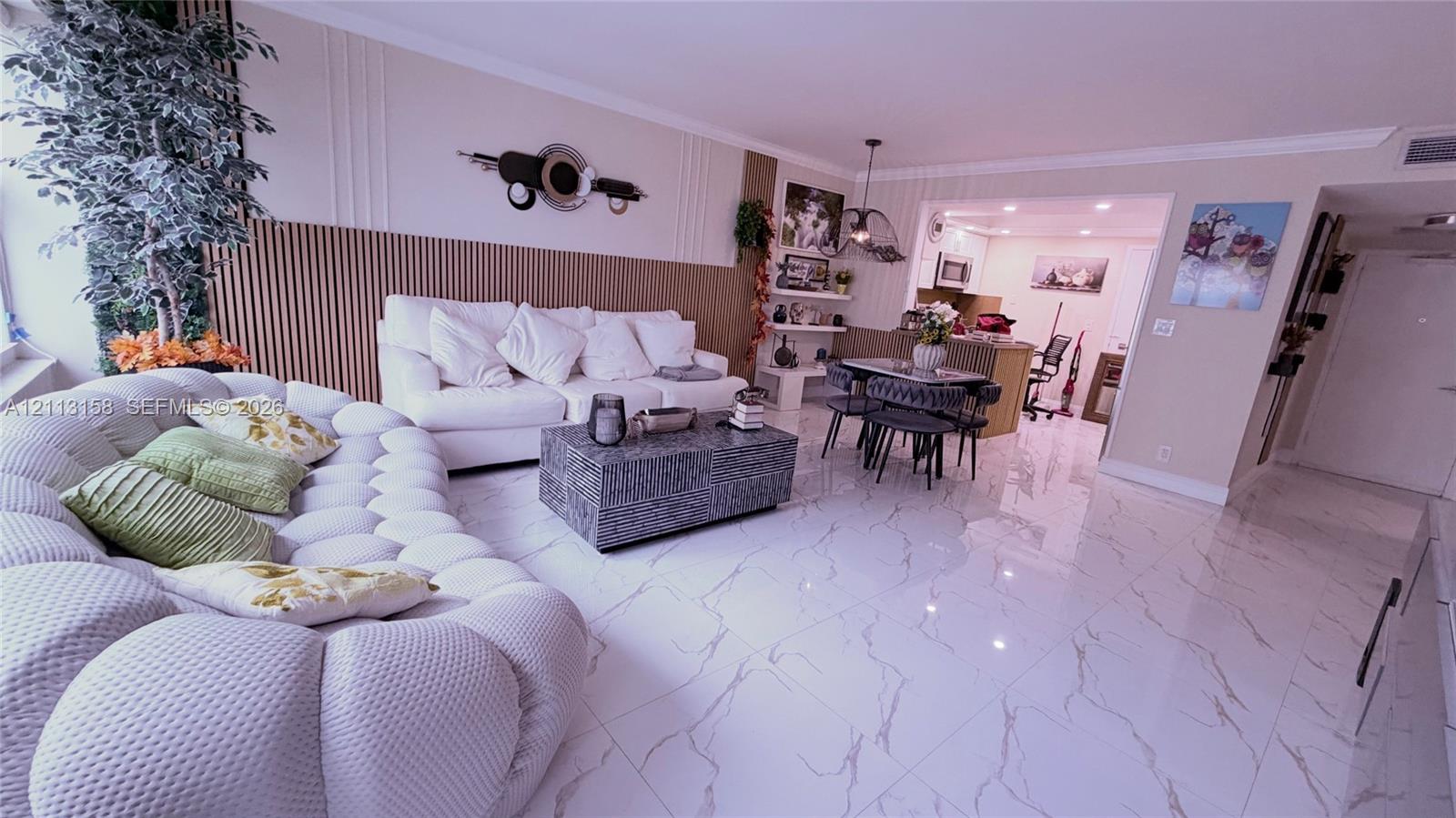 Living area featuring polished tile flooring with stone-patterned veining and floor-to-ceiling vertical wood-slat accent wall paneling Living area featuring polished tile flooring with stone-patterned veining and floor-to-ceiling vertical wood-slat accent wall paneling