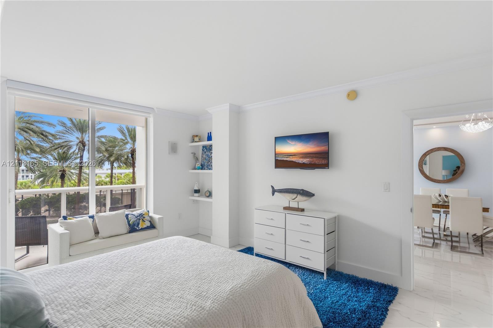 Floor-to-ceiling glass sliding doors, polished stone-finish flooring, built-in recessed shelving, and crown molding