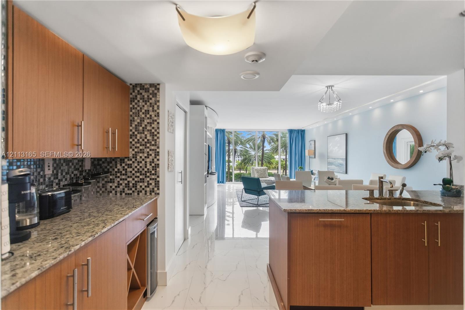 Kitchen featuring flat-panel wood cabinetry, stone countertops, integrated wine storage, mosaic tile backsplash, and stone-finish flooring