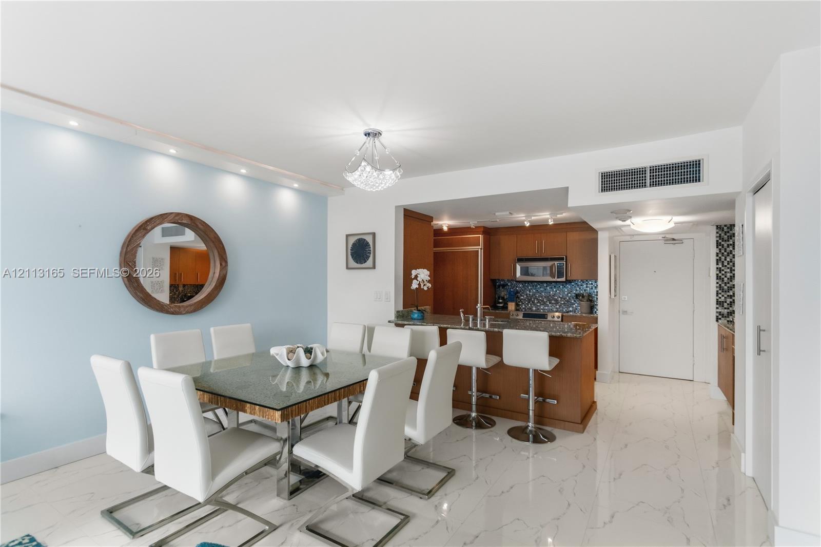 Kitchen featuring wood cabinetry, stone countertops, and integrated appliances with a breakfast bar