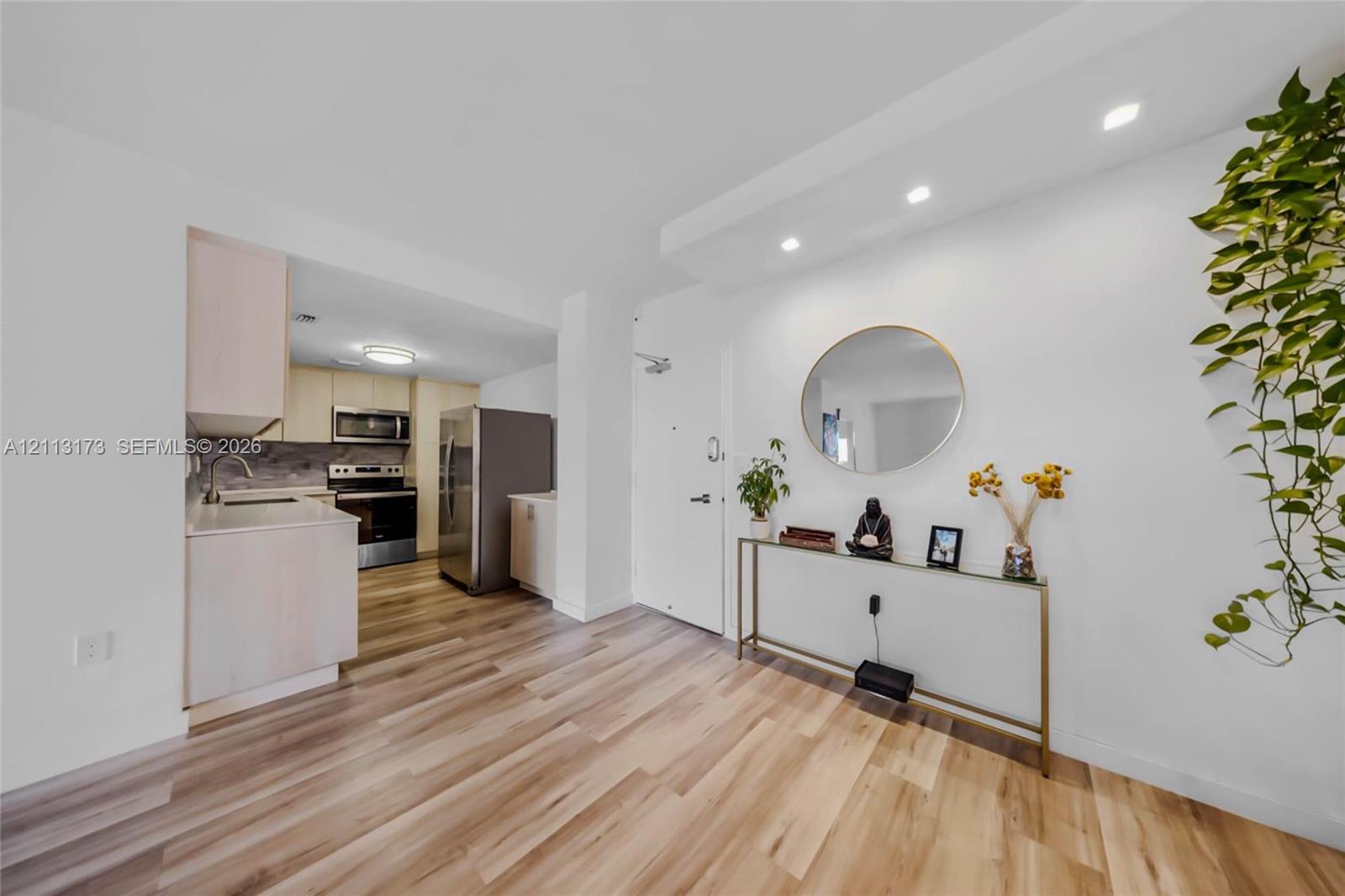 Kitchen featuring light wood-finish cabinetry, stainless steel appliances, and solid surface countertops