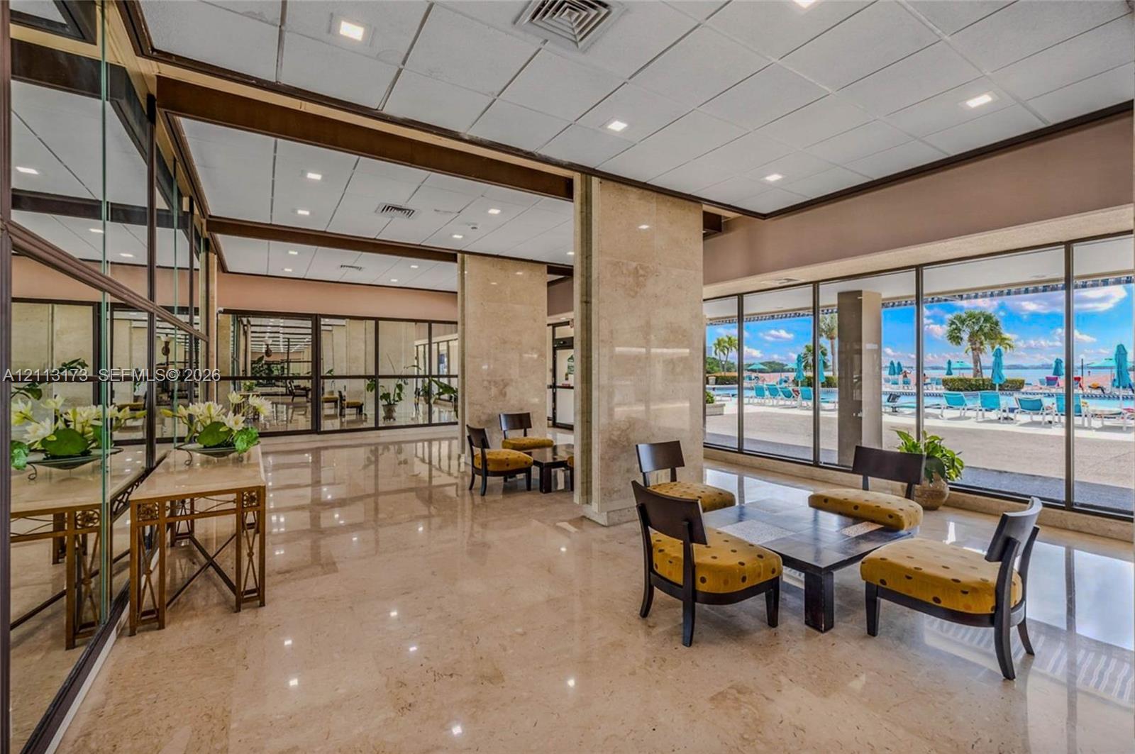 Lobby featuring polished stone flooring, floor-to-ceiling glass walls, recessed lighting, and stone-clad pillars Lobby featuring polished stone flooring, floor-to-ceiling glass walls, recessed lighting, and stone-clad pillars