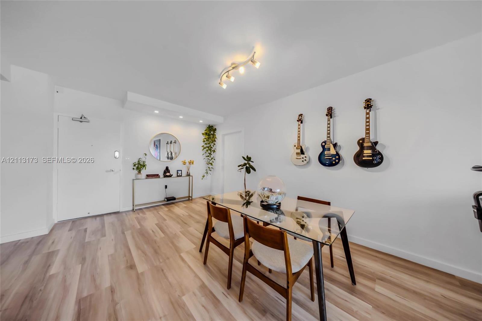 Wood-finish flooring, recessed lighting, and a multi-directional track lighting fixture