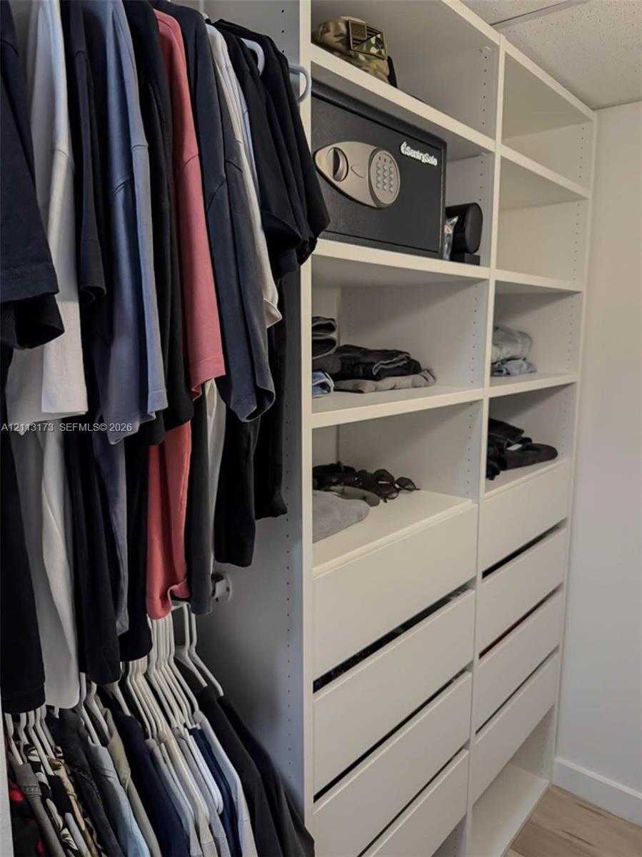 Custom built-in closet organization system featuring floor-to-ceiling shelving, tiered hanging rods, and integrated pull-out drawers