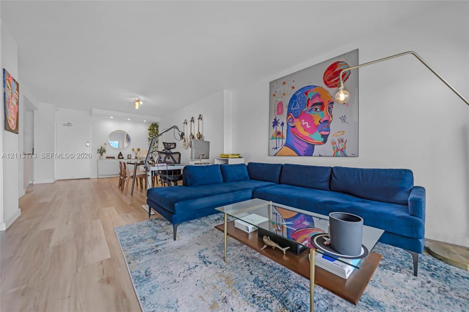 Open-concept interior featuring wood-finish flooring, neutral walls, and recessed lighting