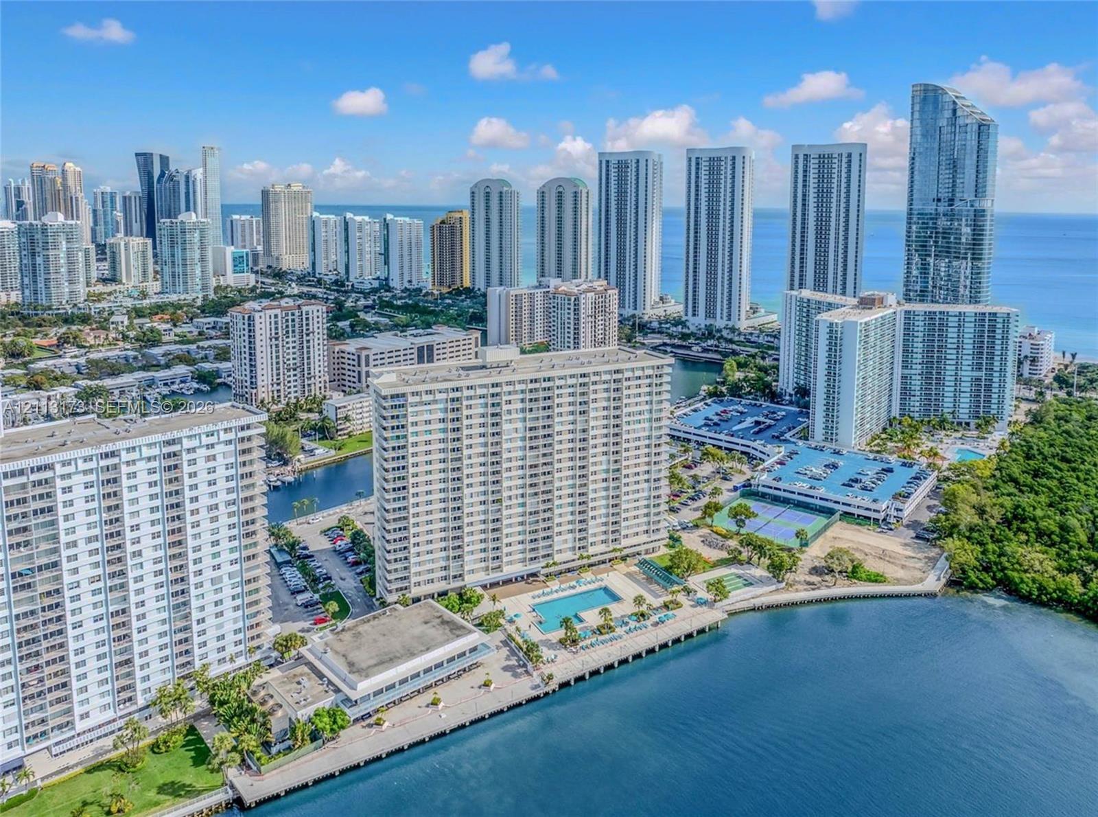 Waterfront high-rise community featuring a swimming pool, tennis courts, paved parking, and direct water access Waterfront high-rise community featuring a swimming pool, tennis courts, paved parking, and direct water access