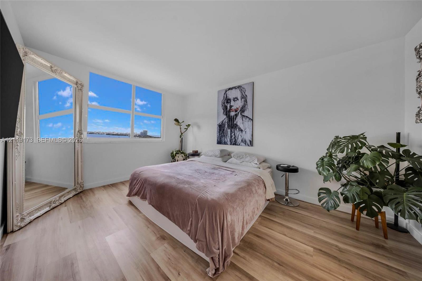 Wood-finish flooring and large multi-pane windows providing natural light and coastal scenery