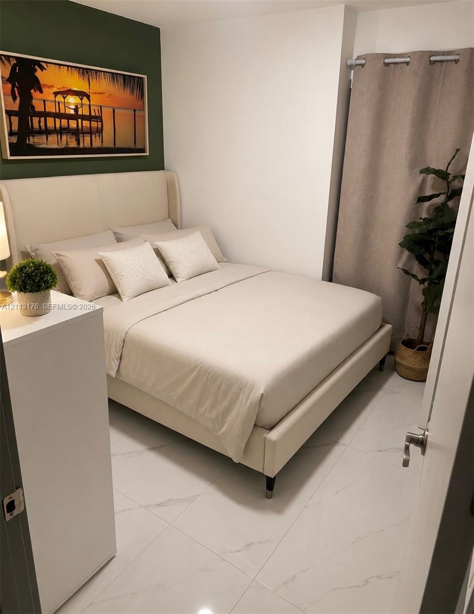 Large-format porcelain tile flooring with marble-pattern veining and an accent wall with a deep green finish