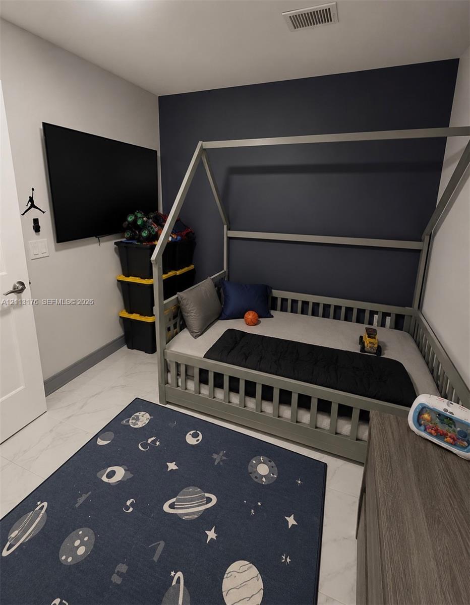 Interior space featuring stone-finish flooring and a charcoal-toned accent wall