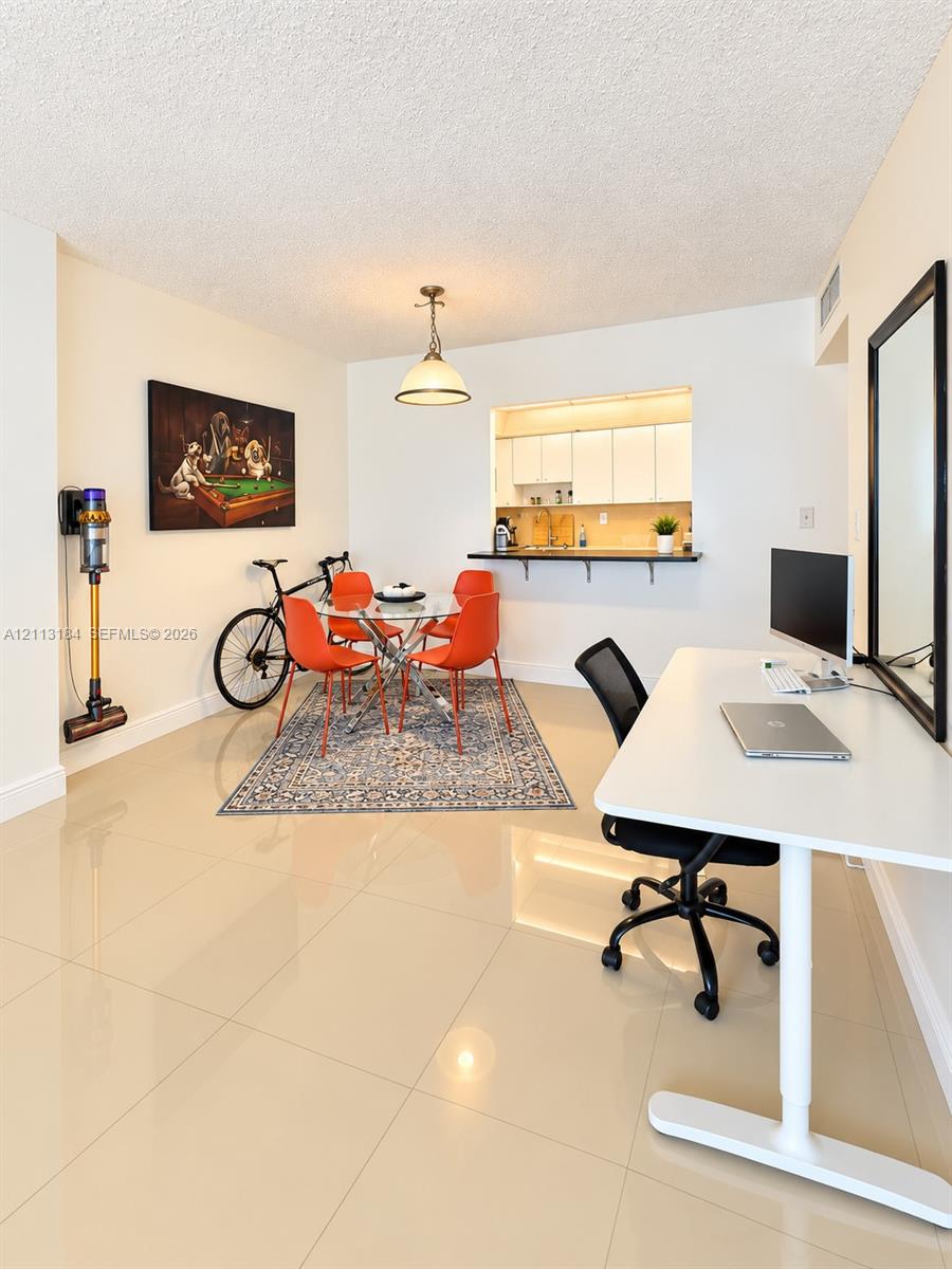 Polished tile flooring throughout, recessed kitchen pass-through window, and pendant lighting