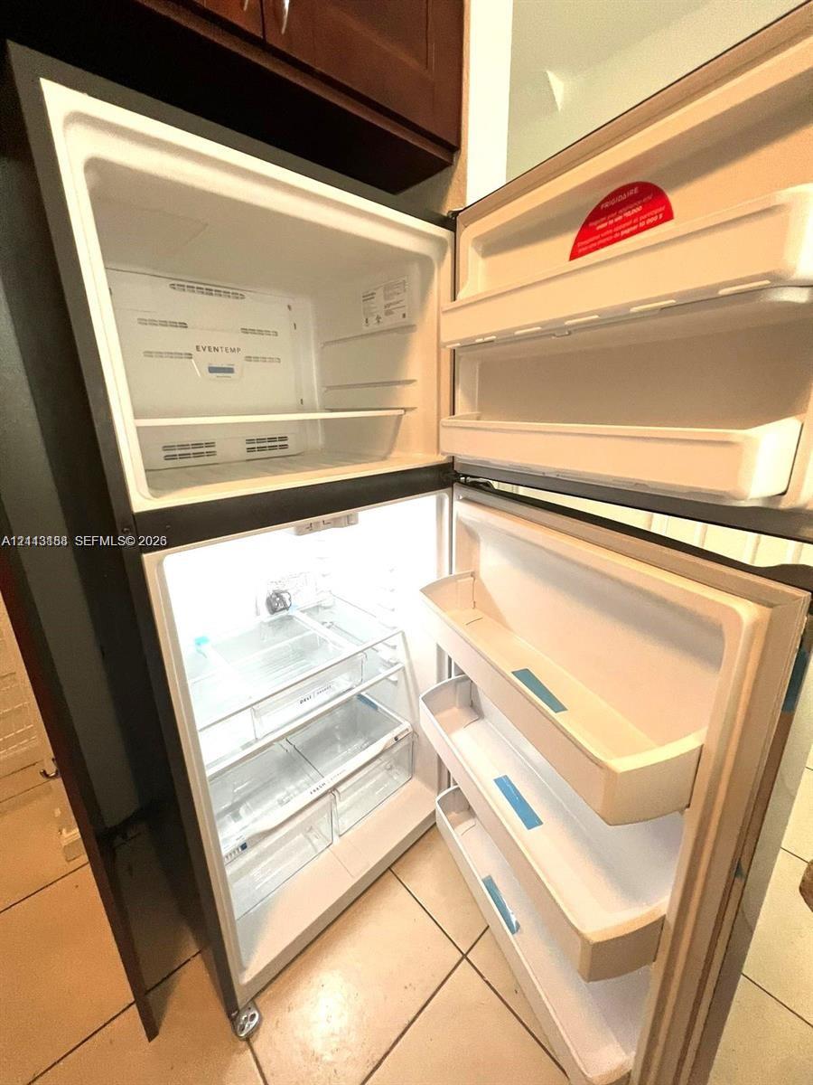 Top-mount refrigerator with adjustable shelving, integrated door storage, and crisper drawers