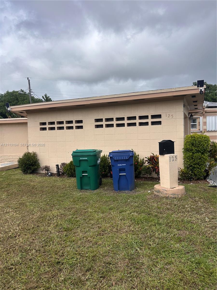 Concrete block exterior featuring decorative horizontal vents and a ground-mounted pedestal mailbox Concrete block exterior featuring decorative horizontal vents and a ground-mounted pedestal mailbox