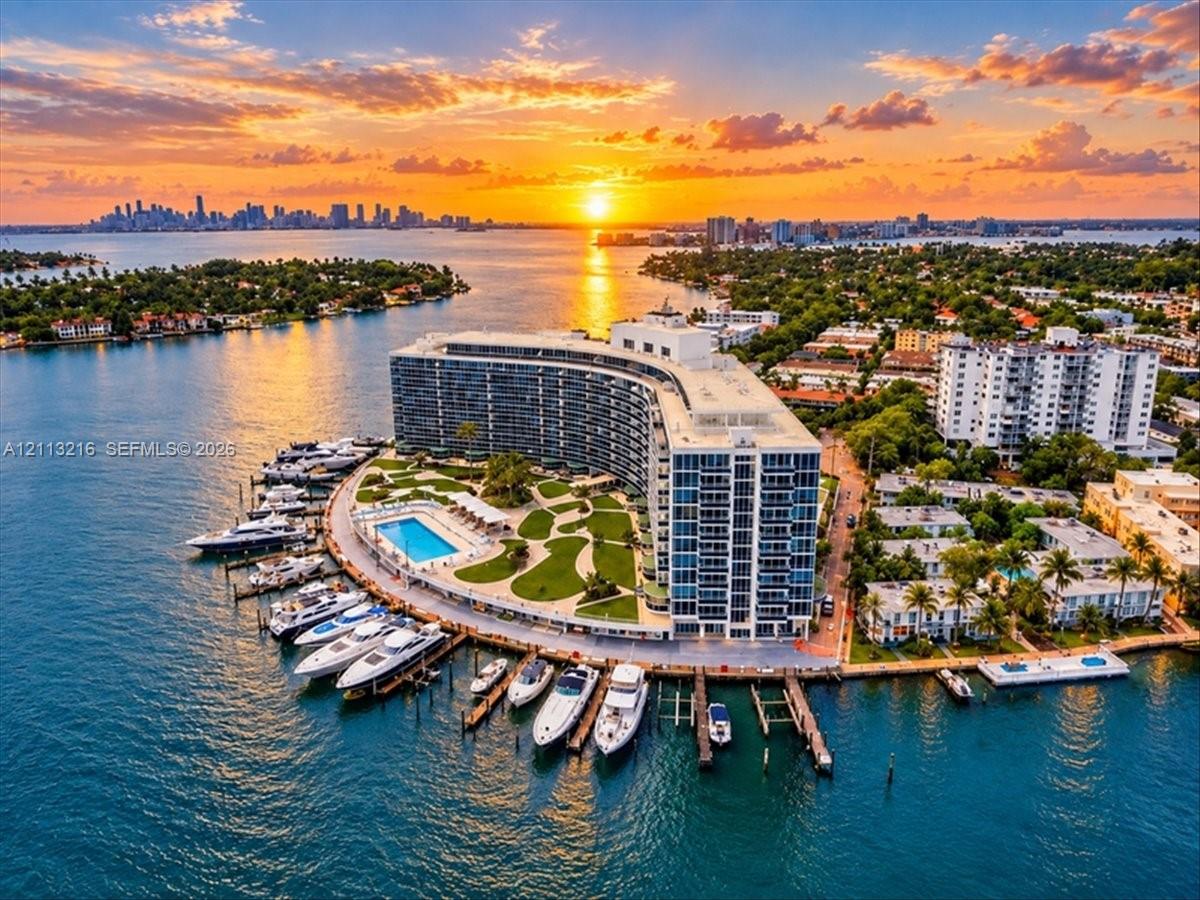 Waterfront property featuring a multi-slip private marina, expansive outdoor swimming pool, landscaped grounds, and curvilinear architectural design Waterfront property featuring a multi-slip private marina, expansive outdoor swimming pool, landscaped grounds, and curvilinear architectural design