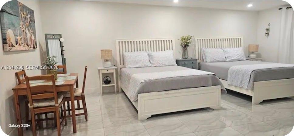 Neutral-toned interior space featuring light-colored polished tile flooring and recessed ceiling lighting