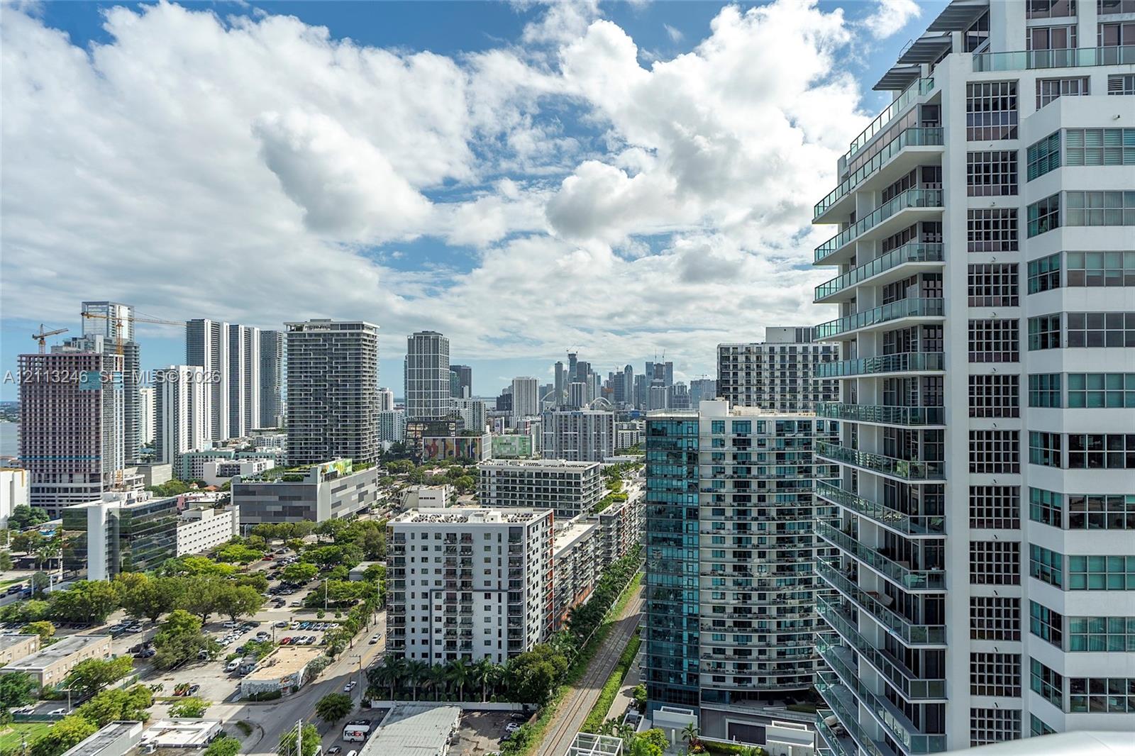 High-rise exterior featuring wraparound balconies with glass railings and white concrete structural facade