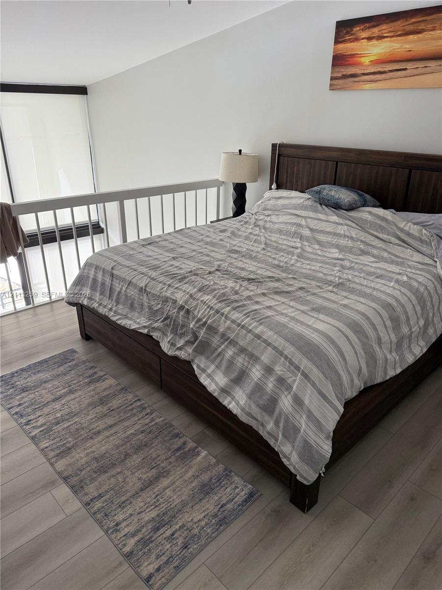 Wood-finish flooring, white railing enclosure, and floor-to-ceiling windows Wood-finish flooring, white railing enclosure, and floor-to-ceiling windows