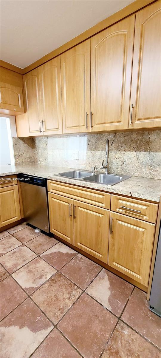 Kitchen featuring light-finish cabinetry, stone countertops, integrated backsplash, stainless steel dishwasher, and ceramic tile flooring