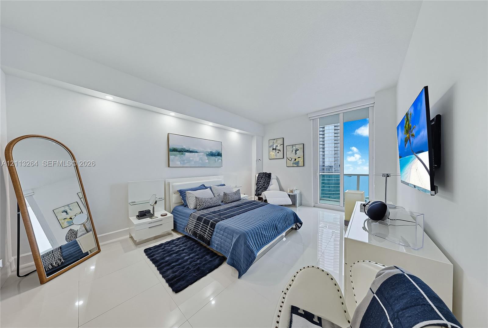 Interior space featuring large-format tile flooring, recessed architectural lighting, and floor-to-ceiling glass paneling with balcony access Interior space featuring large-format tile flooring, recessed architectural lighting, and floor-to-ceiling glass paneling with balcony access