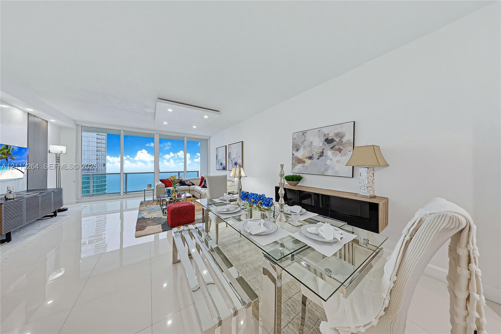 Open-concept interior featuring large-format tile flooring, recessed ceiling lighting, and floor-to-ceiling glass panel walls Open-concept interior featuring large-format tile flooring, recessed ceiling lighting, and floor-to-ceiling glass panel walls