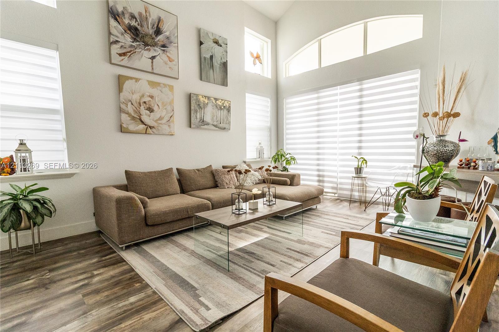Vaulted ceilings, expansive windows, arched transom window, and wood-finish flooring