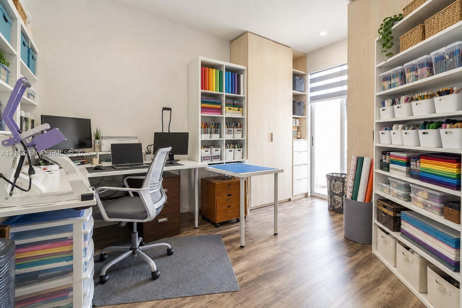 Built-in floor-to-ceiling light-wood cabinetry, wood-finish flooring, and a glass-paneled door with integrated window treatments