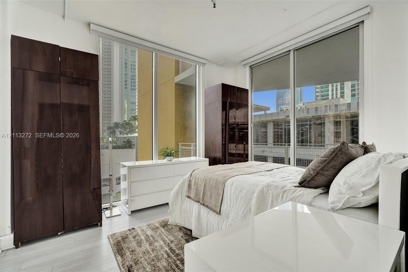 Floor-to-ceiling windows, neutral interior paint, and light-toned flooring
