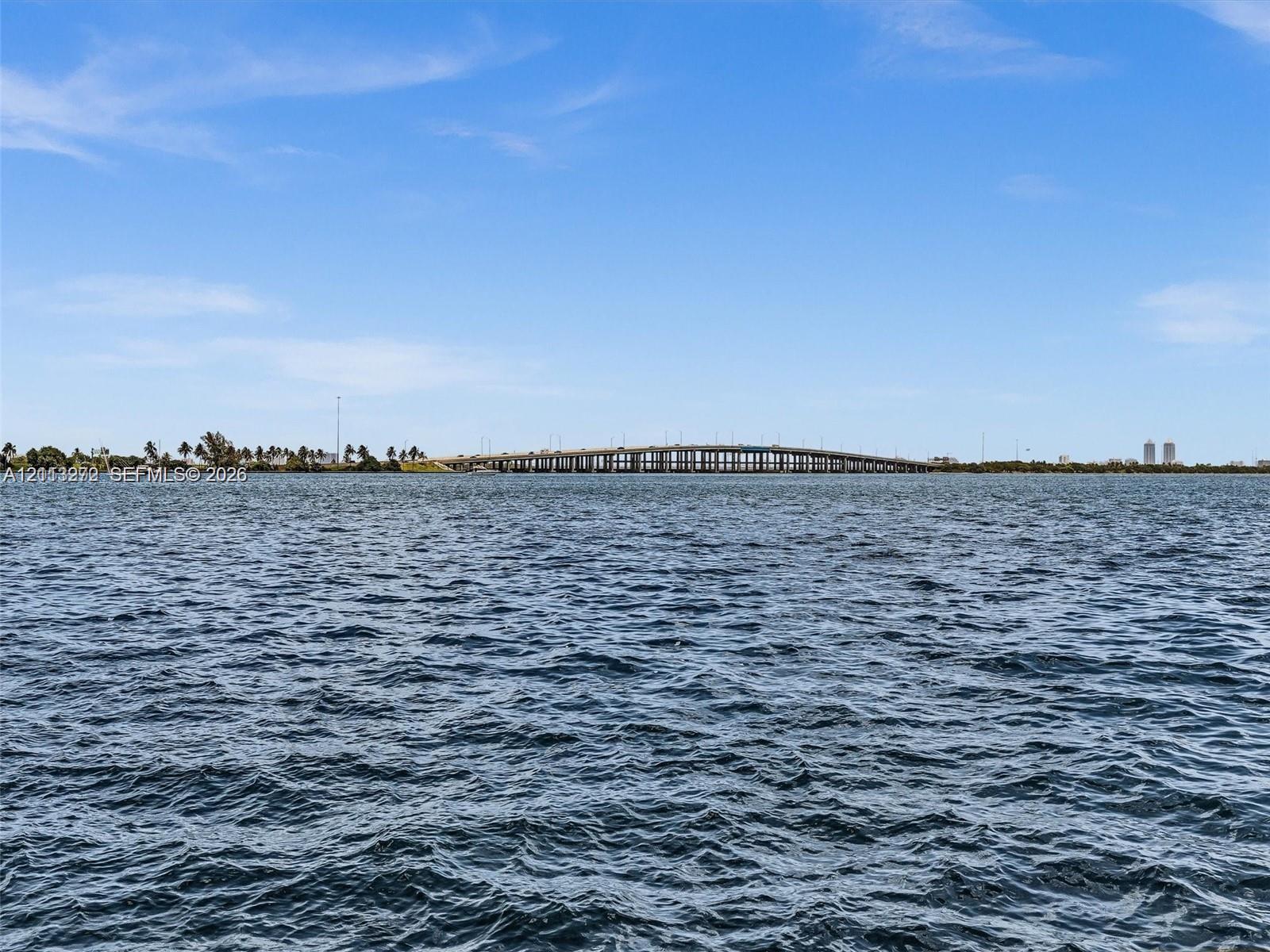 Waterfront perspective featuring open-water exposure and a distant bridge silhouette