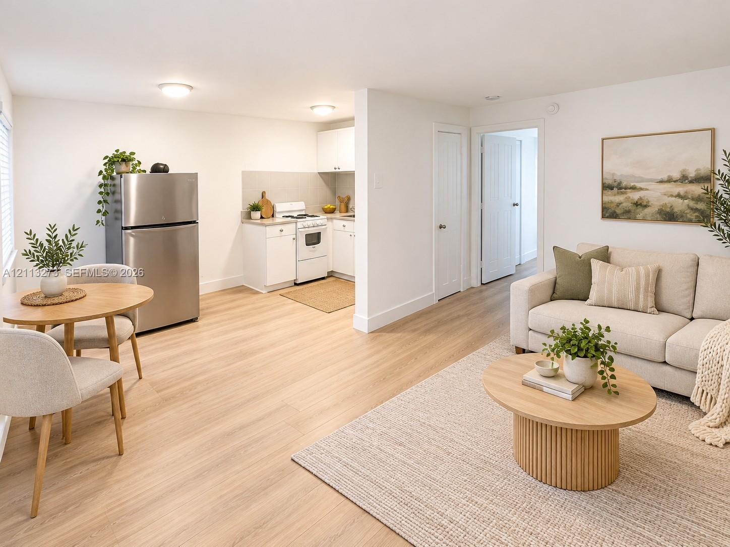Kitchen area featuring white cabinetry, integrated stainless steel refrigerator, and wood-finish flooring throughout Kitchen area featuring white cabinetry, integrated stainless steel refrigerator, and wood-finish flooring throughout