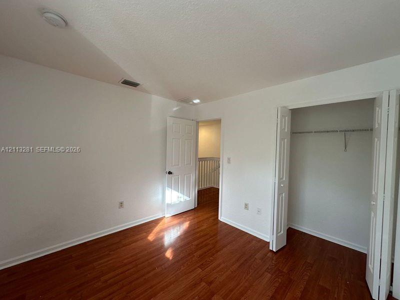 Wood-finish flooring, six-panel interior doors, and closet with built-in metal shelving