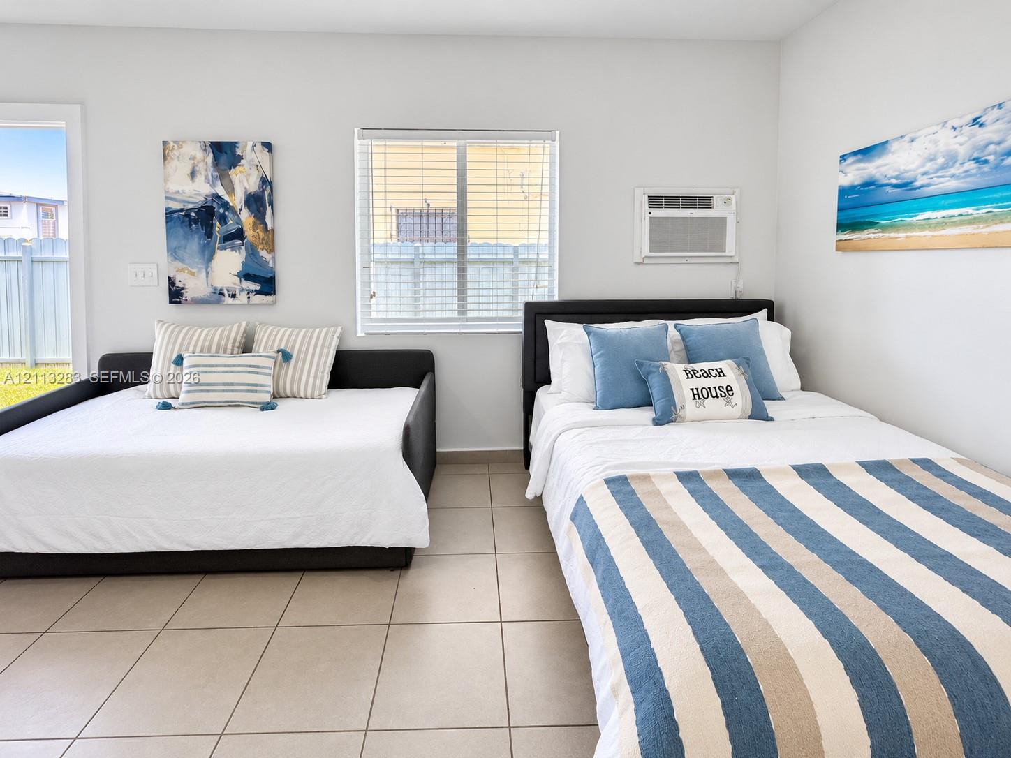 Neutral-toned ceramic tile flooring, horizontal window blinds, and integrated wall-mounted cooling unit