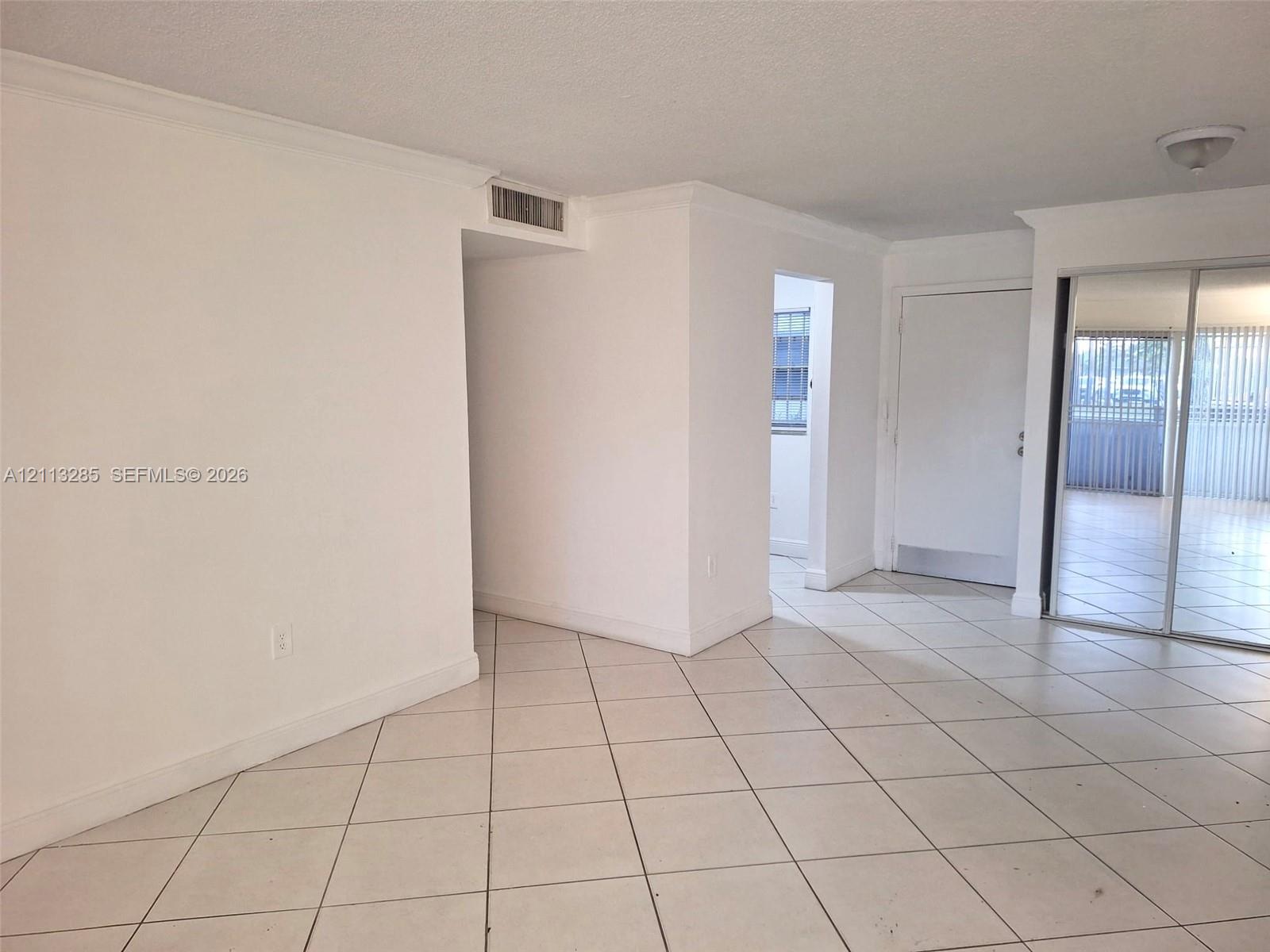 Neutral-toned ceramic tile flooring, mirrored sliding closet doors, flush-mount ceiling lighting, and crown molding Neutral-toned ceramic tile flooring, mirrored sliding closet doors, flush-mount ceiling lighting, and crown molding
