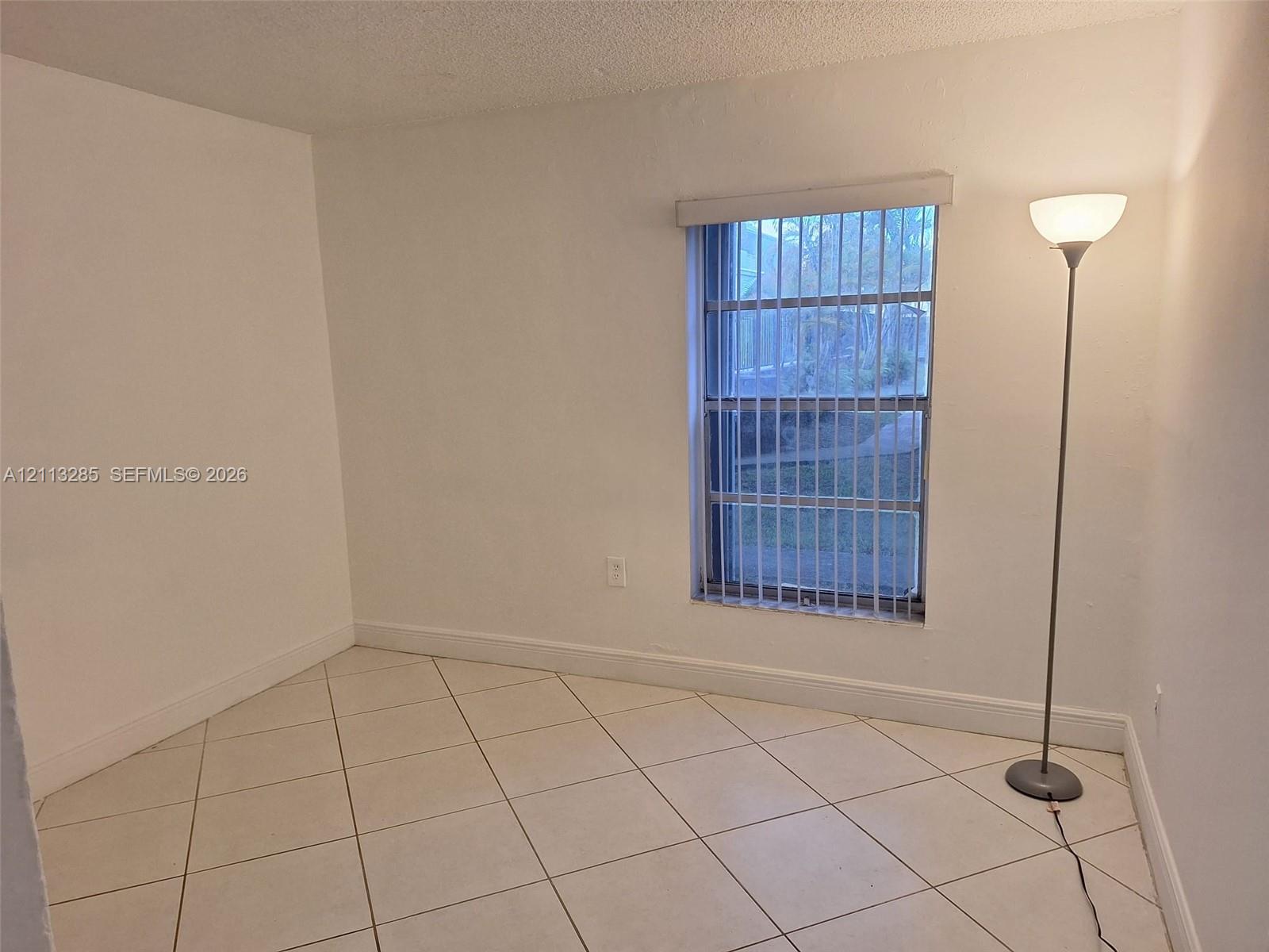 Neutral-toned ceramic tile flooring, vertical window blinds, and crisp white wall finishes Neutral-toned ceramic tile flooring, vertical window blinds, and crisp white wall finishes