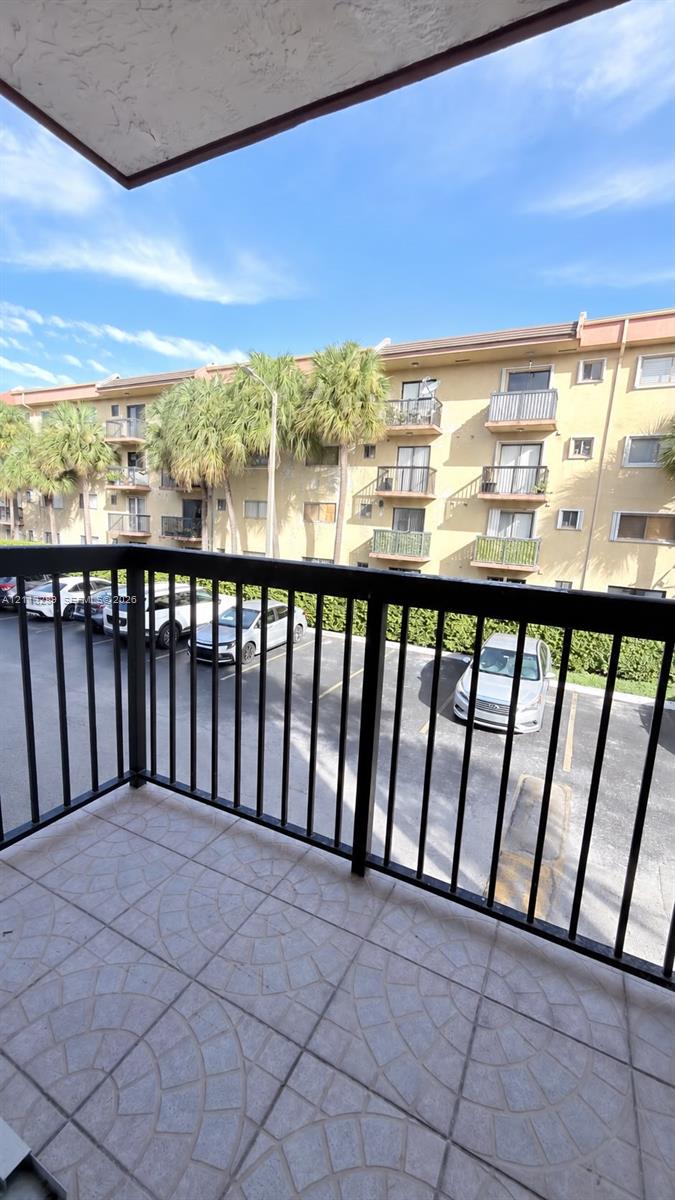 Private balcony with dark metal railings and decorative stone-tile flooring