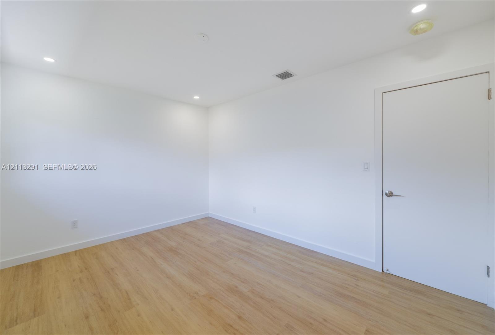 Interior space featuring wood-finish flooring, white walls, and recessed lighting