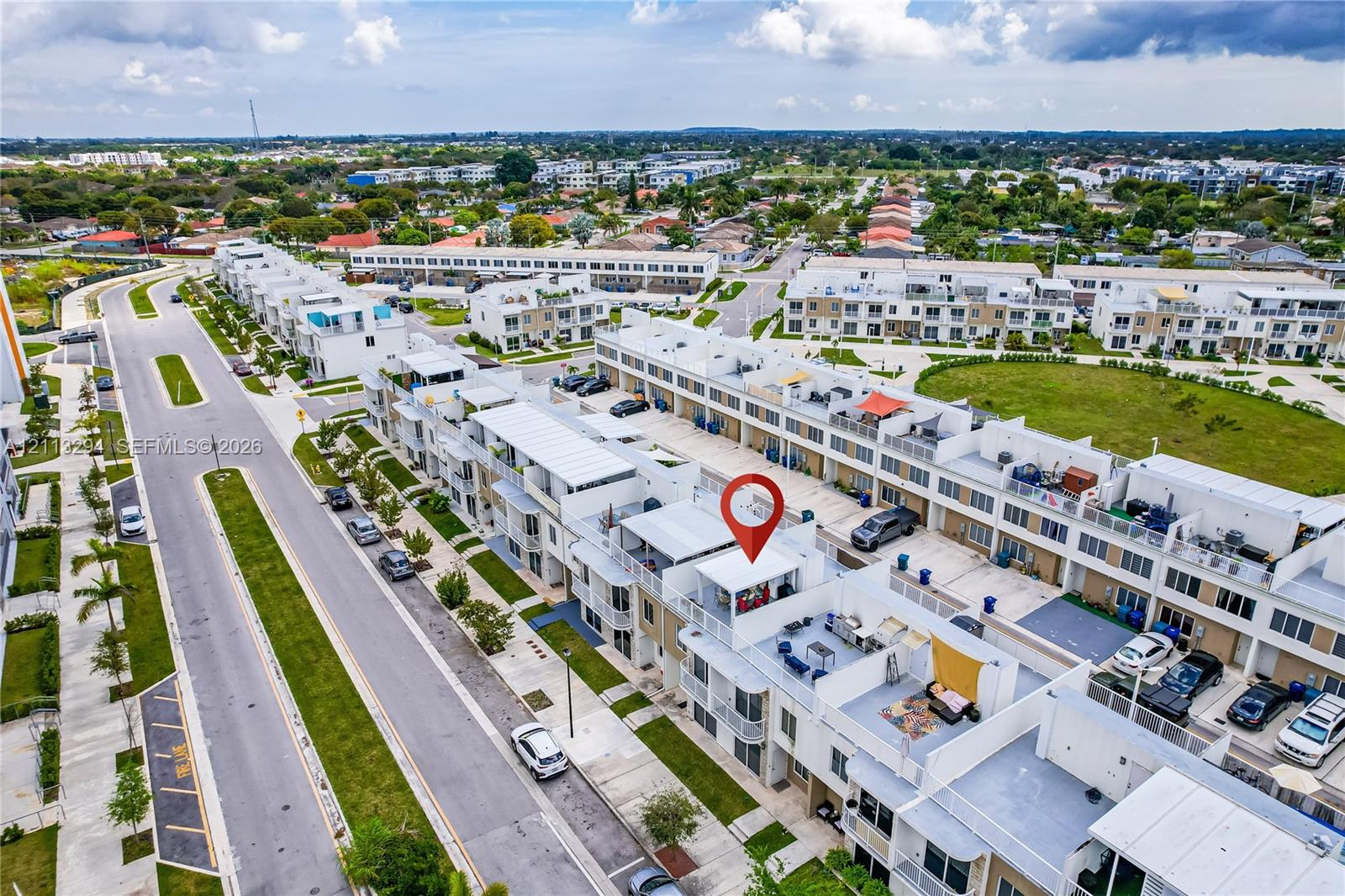 Aerial perspective of a multi-level residential structure featuring a private rooftop terrace, balcony spaces, and paved driveway parking Aerial perspective of a multi-level residential structure featuring a private rooftop terrace, balcony spaces, and paved driveway parking