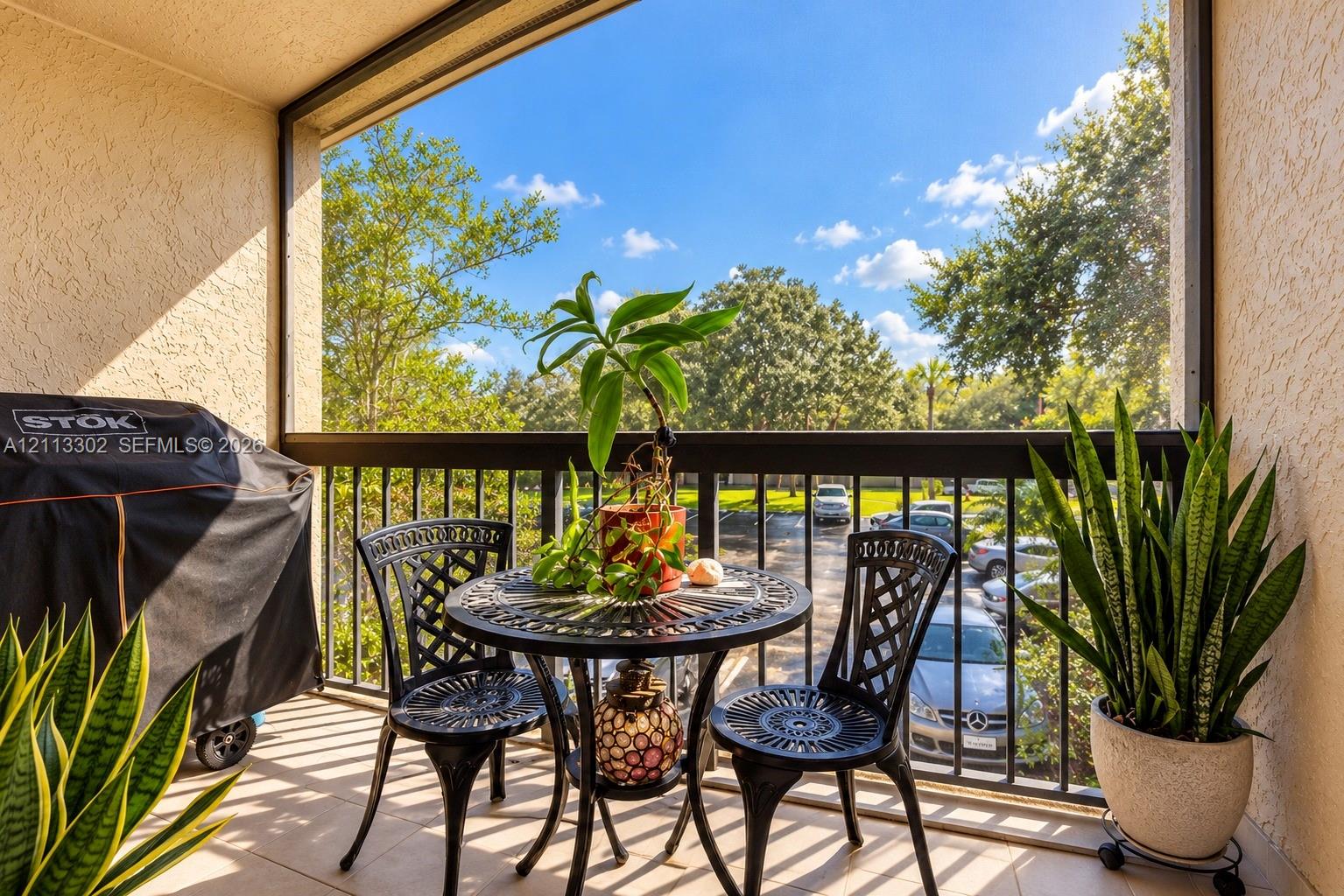 Screened balcony featuring tile flooring, textured wall finishes, and metal railings