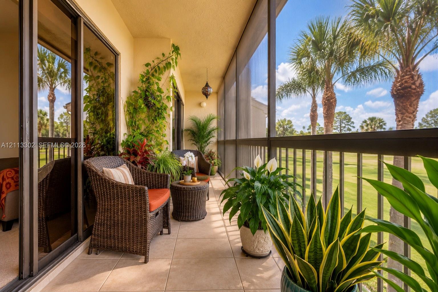 Screened-in balcony featuring tile flooring, metal railings, and sliding glass door access