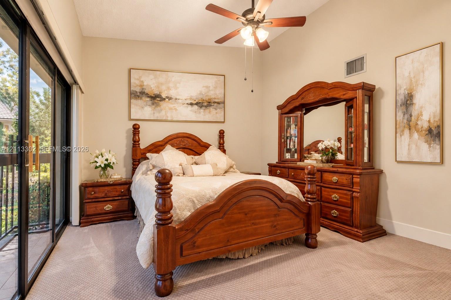 Neutral-toned room featuring a ceiling fan with integrated lighting and sliding glass doors