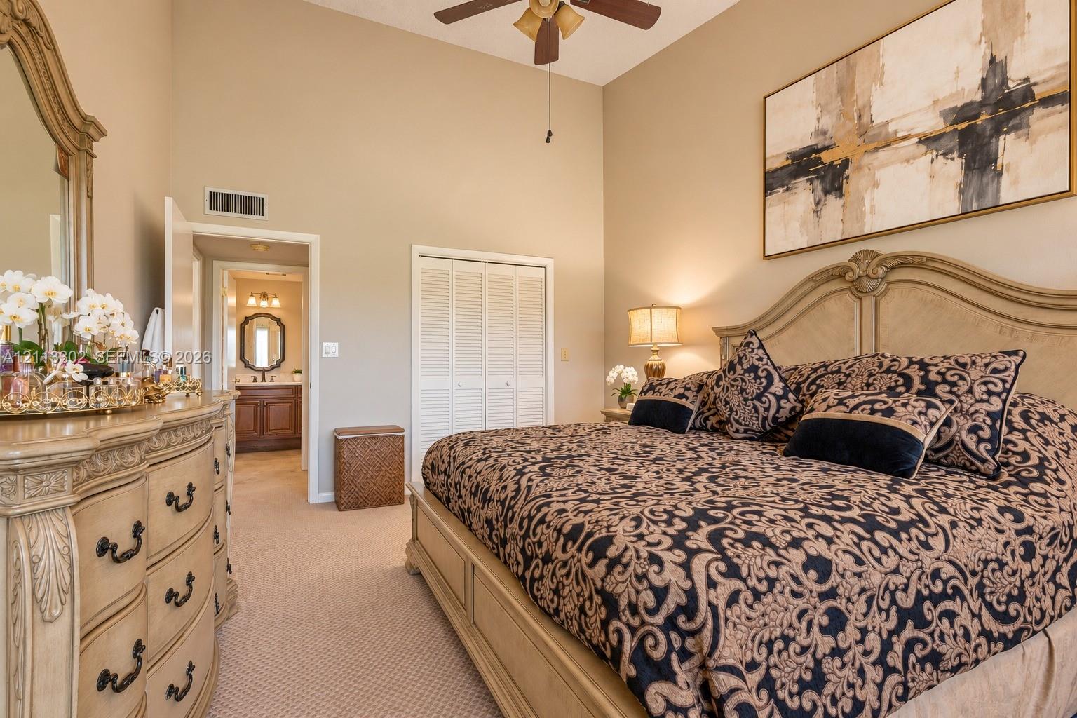 Vaulted ceilings, carpeting, dual-paneled closet doors, and an attached ceiling fan